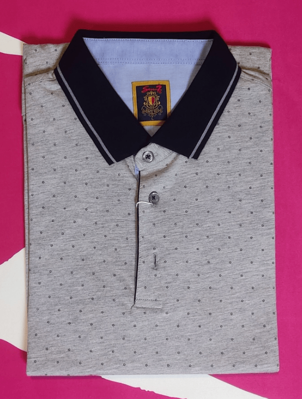 A folded polo-shirt pictured with normal mobile phone